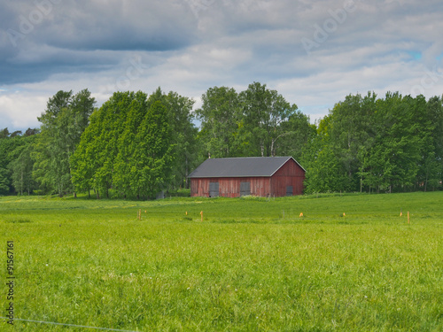 Old barn on a green field in Finland