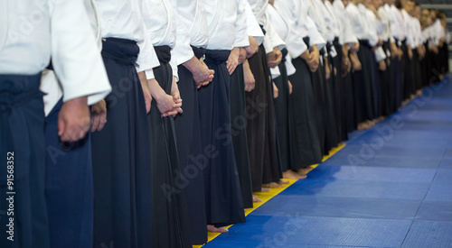 People in kimono and hakama standing in a long line on martial arts training seminar. Selective focus