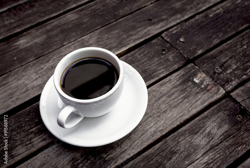 Hot black coffee with space on dark wooden floor