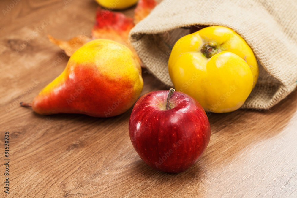Red apple, pear and quince in small sack Red apple, pear and quince in small sack