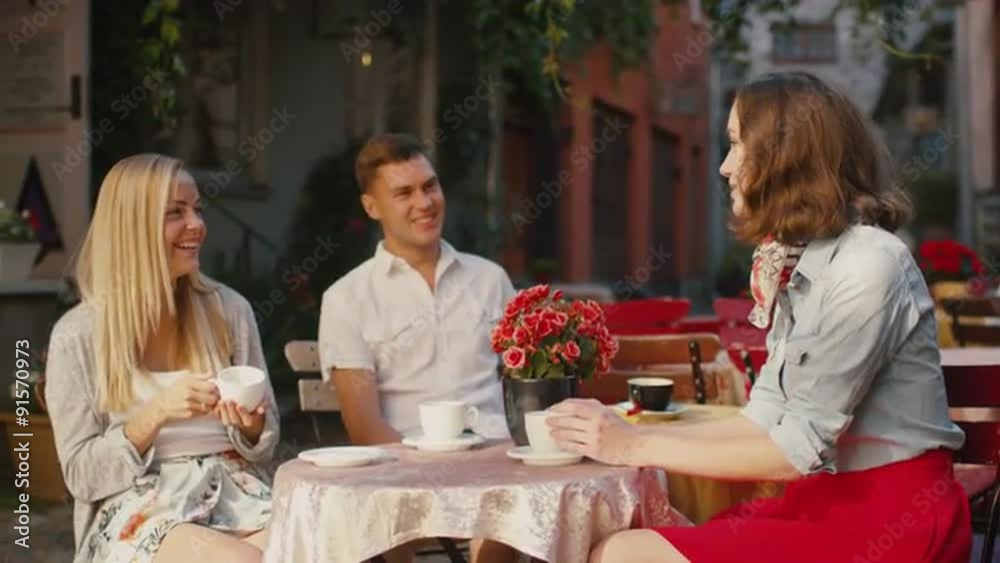 Happy Young People are Talking in Outdoor Coffee Shop Happy Young People are Talking in Outdoor Coffee Shop