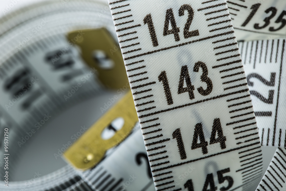 Curved measuring tape. Measuring tape of the tailor. Closeup view of white measuring tape Curved measuring tape. Measuring tape of the tailor. Closeup view of white measuring tape