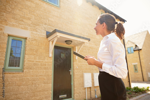 Εκτύπωση καμβά Female real estate agent looking at a house exterior