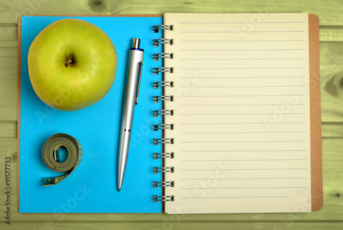 Notebook with apple fruit and centimeter