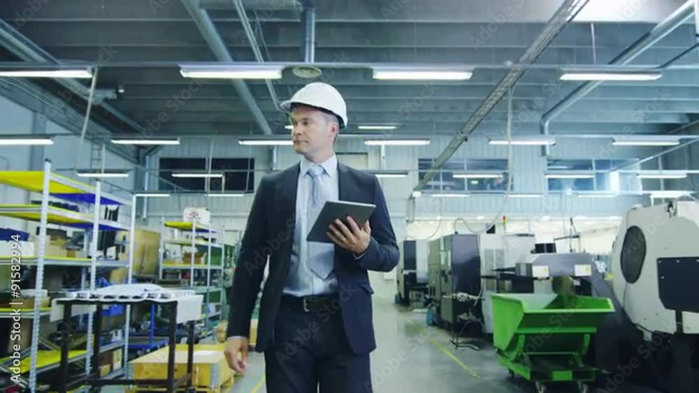 Businessman with Tablet PC is Walking though Factory