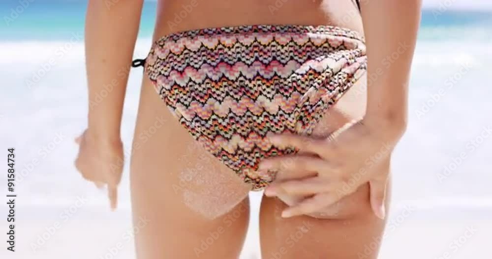 Stockvideo Rear view close up beautiful young girls wiping beach sand off ass wearing string bikini sexy butt tropical vacation | Adobe Stock 