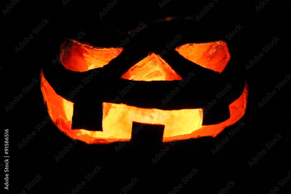 Fototapeta premium Scary Halloween pumpkin lit in the dark