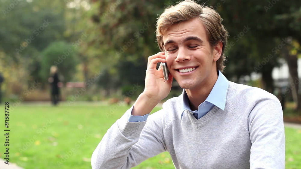 man using mobile phone outdoors in park