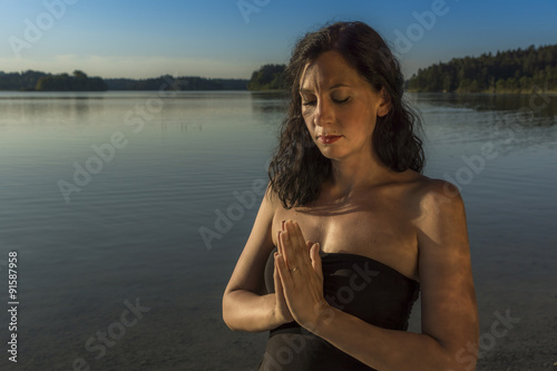 Junge Frau stimmt sich meditativ auf Yoga ein