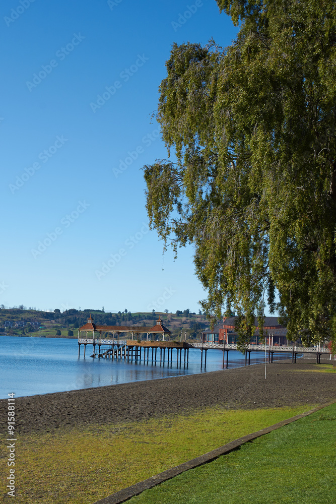 Wooden pier stretching out over the calm waters of Lake Llanquihue in the small town of Frutillar in southern Chile.