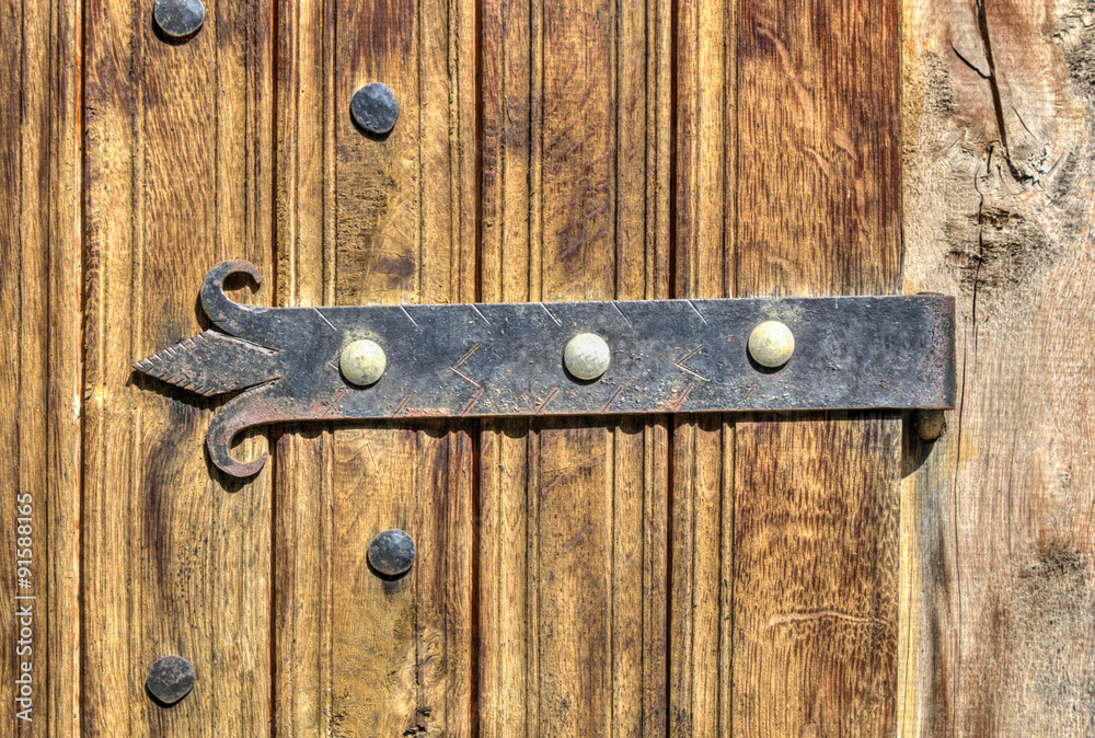 Stylish wooden door with metal ornaments closeup