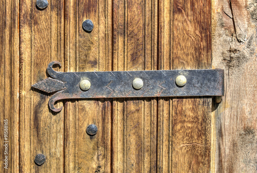 Stylish wooden door with metal ornaments closeup
