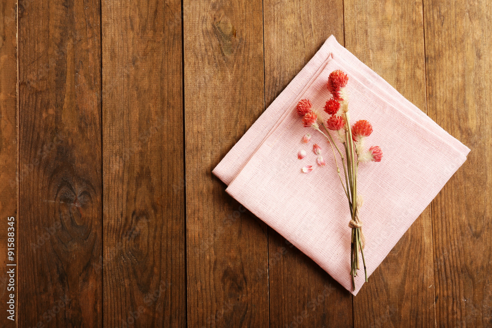 Beautiful dry flowers on napkin on wooden background Beautiful dry flowers on napkin on wooden background