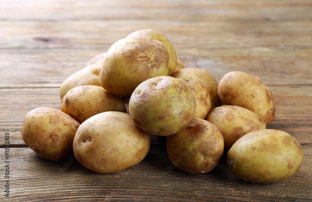 Young potatoes on wooden table close up Young potatoes on wooden table close up