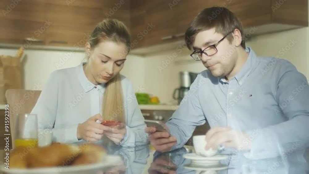 Boyfriend and Girlfriend are Using Their Phones at Breakfast Boyfriend and Girlfriend are Using Their Phones at Breakfast