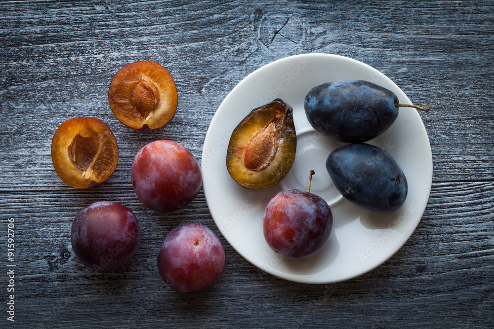 Obraz premium Fresh plums on a rustic wooden table
