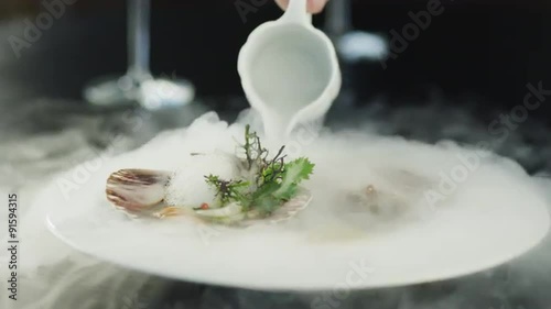 Chef Garnishing Scallops with Dry Ice in Luxury Restaurant. photo