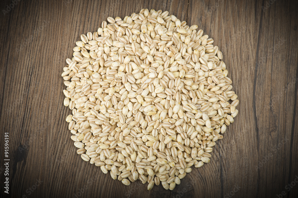 Spoon of Pearl barley close up on a table