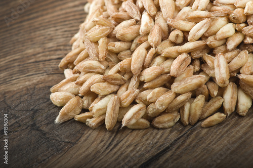 Spoon of Raw Organic Spelt Grain close up on a table