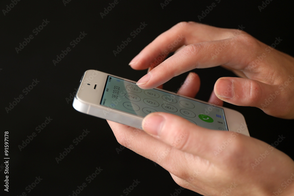 Finger touch number on smartphone to make a call on black background Finger touch number on smartphone to make a call on black background