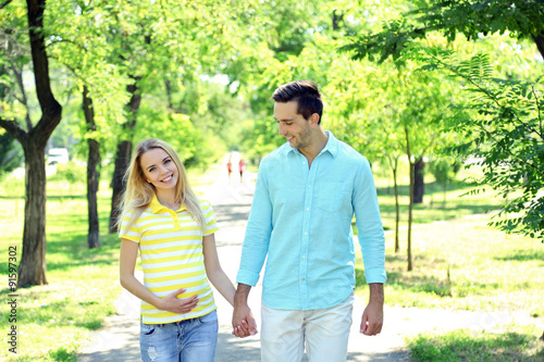 Young pregnant woman with husband in park