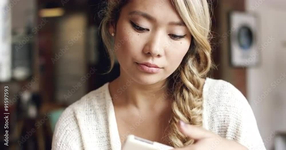 Asian woman using smartphone touchscreen  in cafe drinking coffee