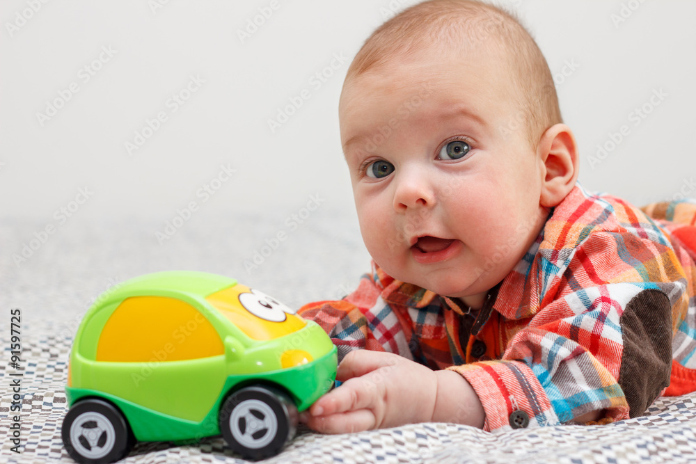 Baby lying on his stomach and plays with the machine Baby lying on his stomach and plays with the machine