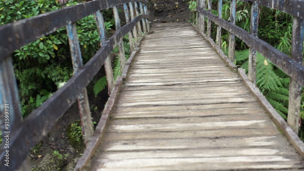 Handheld point of view shot crossing an old hanging pedestrian bridge in Ecuador made of rustic wooden planks and old cables. Handheld point of view shot crossing an old hanging pedestrian bridge in Ecuador made of rustic wooden planks and old cables.