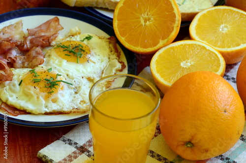 Rustic breakfast - roasted bread with butter and chives, fried eggs and bacon.