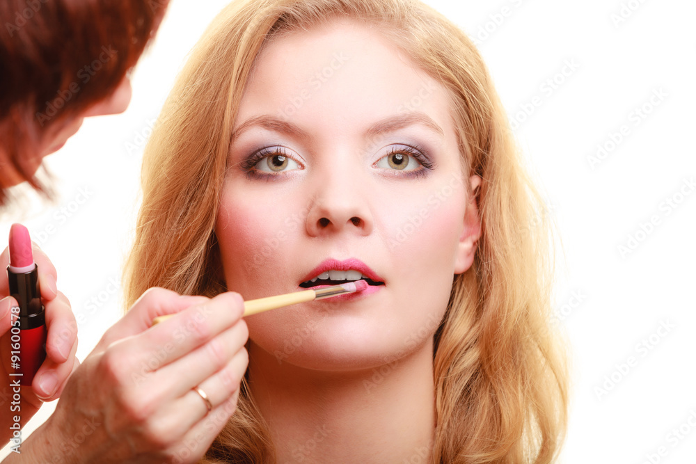 Makeup. Woman applying red lipstick with brush Makeup. Woman applying red lipstick with brush