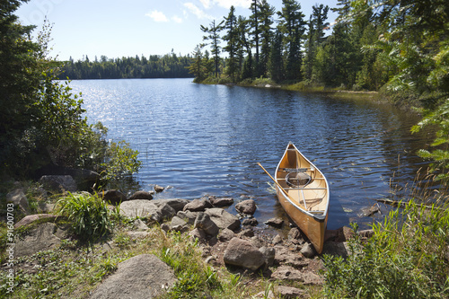 Fototapeta Naklejka Na Ścianę i Meble -  A fisherman's canoe on rocky shore in northern Minnesota lake