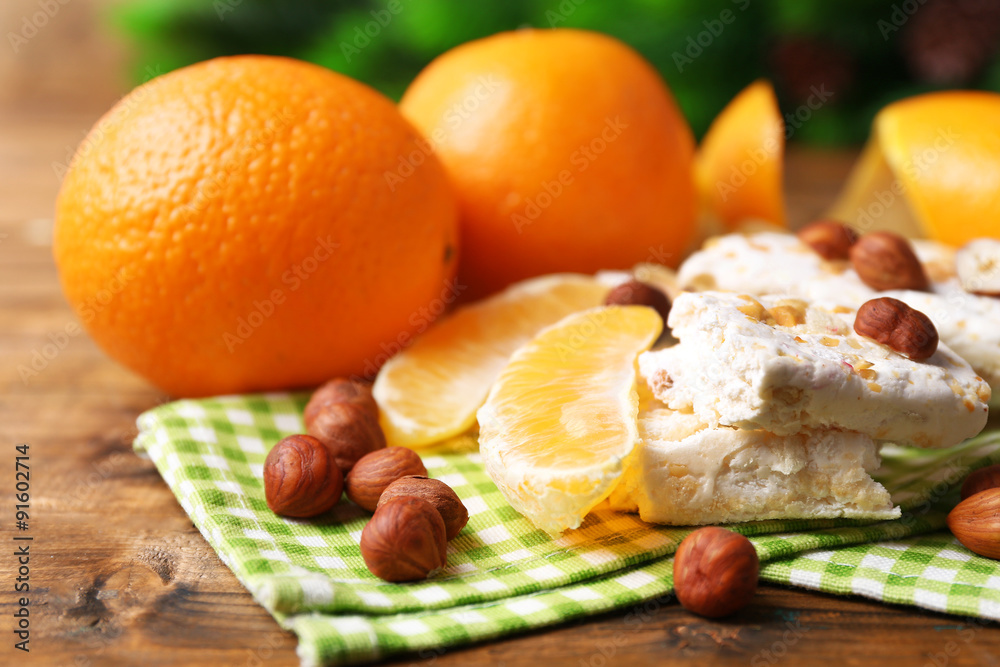 Sweet nougat with hazelnuts and oranges on table close up Sweet nougat with hazelnuts and oranges on table close up