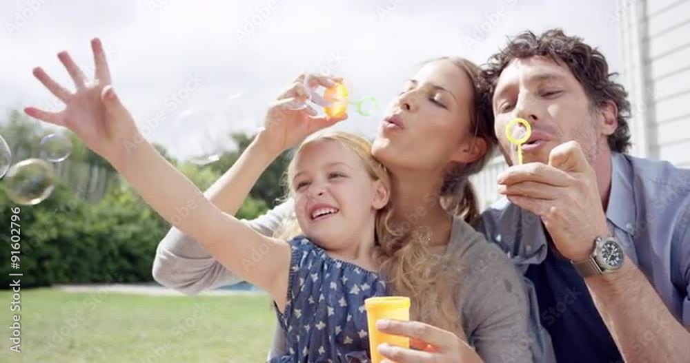 Happy family blowing bubbles in the yard at home Happy family blowing bubbles in the yard at home