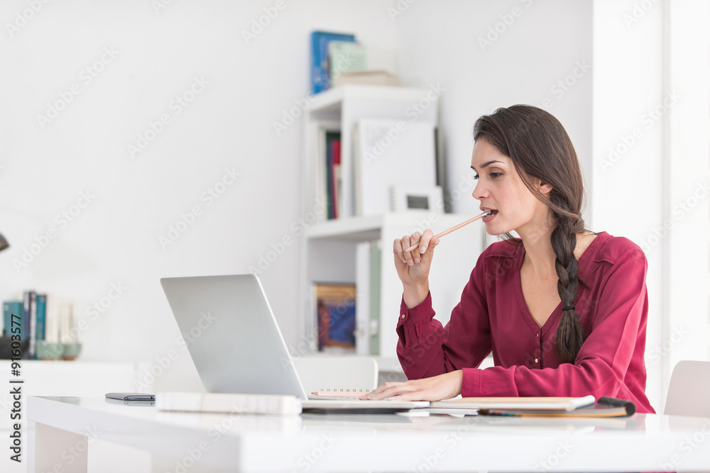 Portrait of a dark braided hair woman chewing her pencil while Portrait of a dark braided hair woman chewing her pencil while
