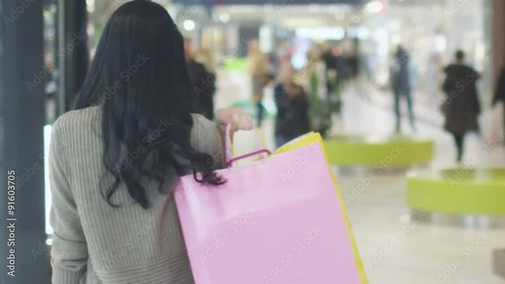 Portrait of Young Girl with Bags in Shopping Mall. Slow Motion.