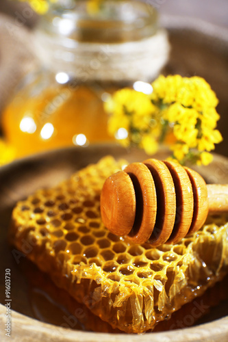 Dipper on honeycomb in bowl, close-up