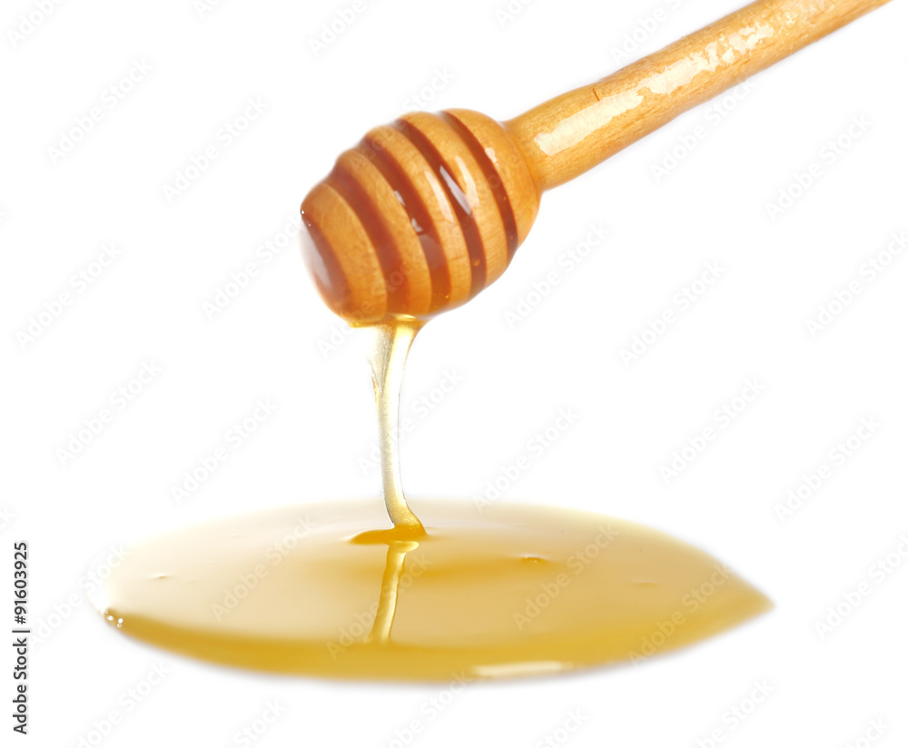 Honey dripping from dipper on light surface Honey dripping from dipper on light surface