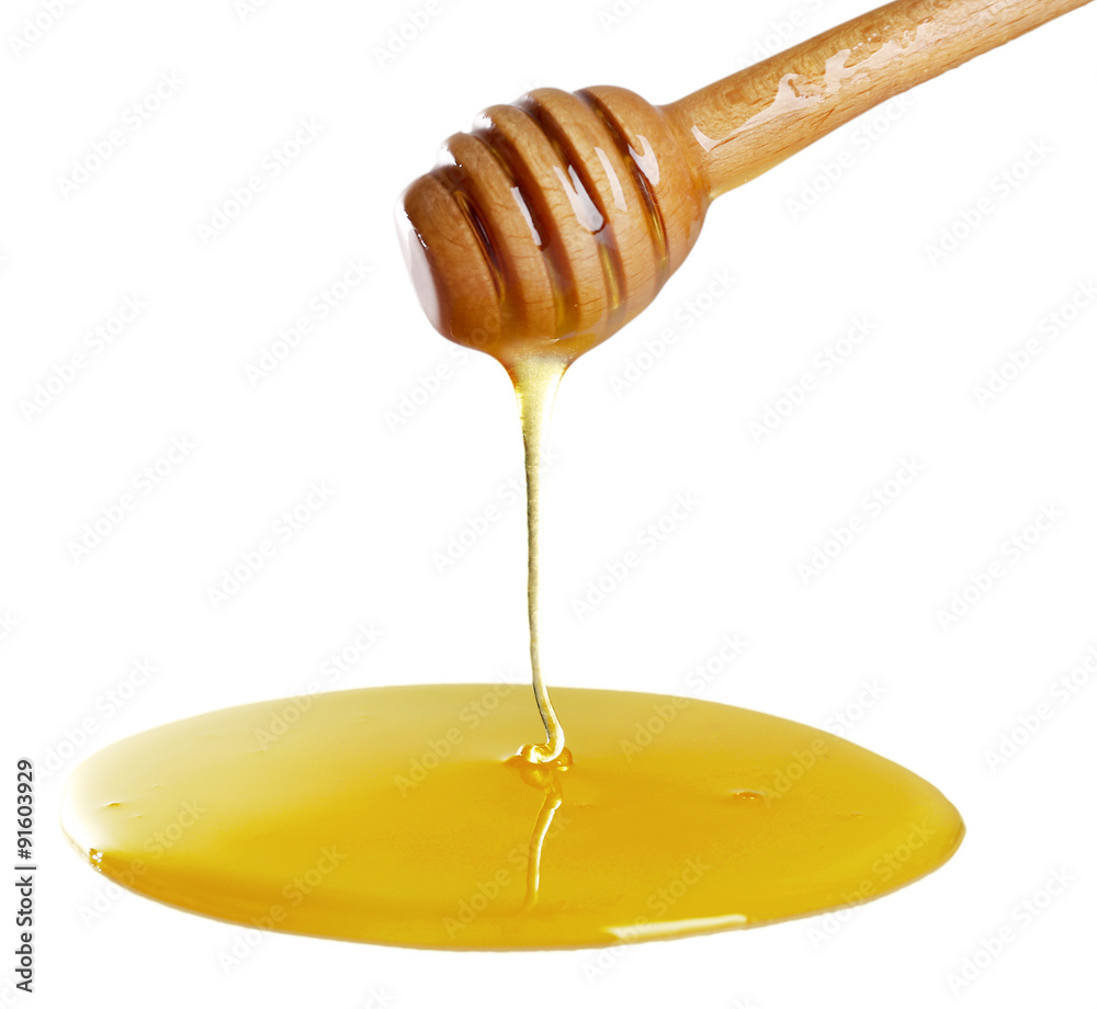 Honey dripping from dipper on light surface Honey dripping from dipper on light surface