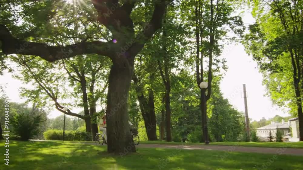 Happy Adult Couple Riding Bicycles in Park. Happy Adult Couple Riding Bicycles in Park.