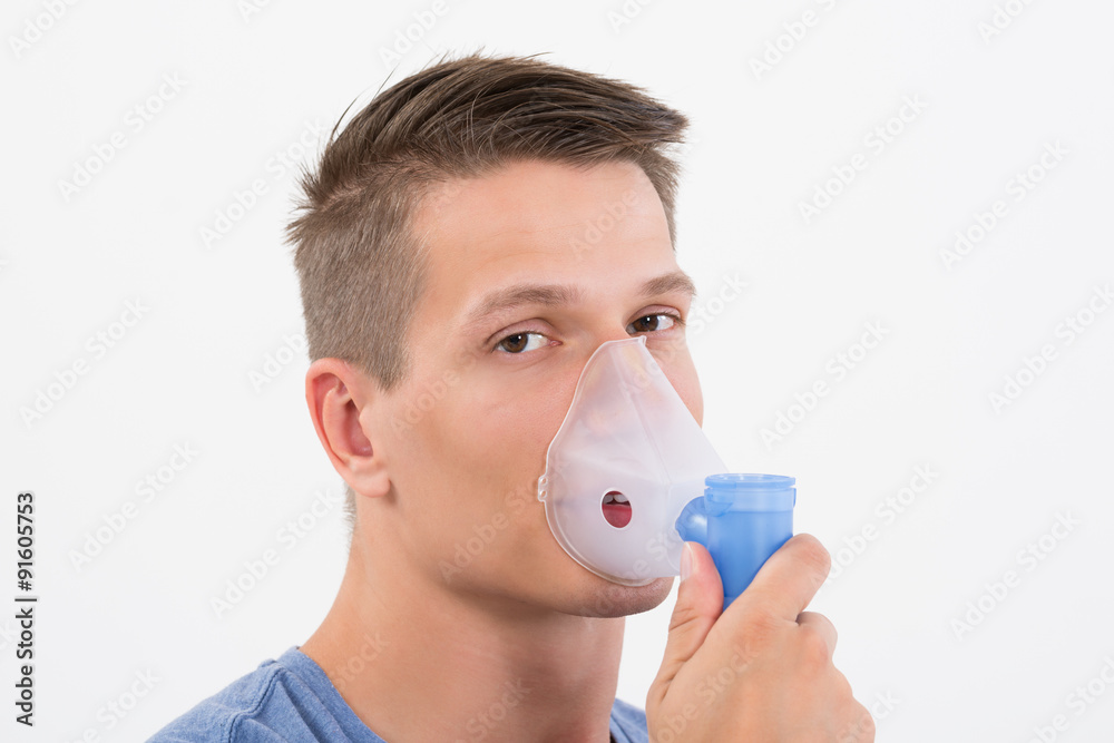 Man Inhaling Through Inhaler Mask Man Inhaling Through Inhaler Mask