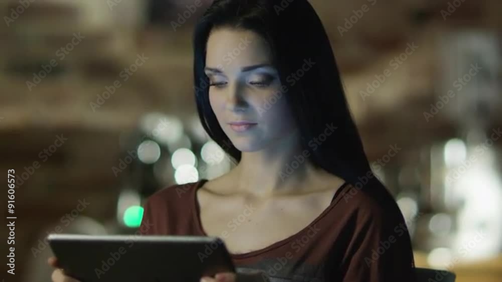 Teen Girl With Beautiful Smile is Using Tablet PC at Evening. Casual Lifestyle.