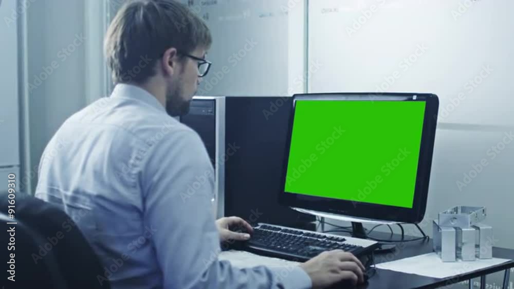 Engineer is Working on Computer. Display with Green Screen. Great for Mock-up Usage. Engineer is Working on Computer. Display with Green Screen. Great for Mock-up Usage.