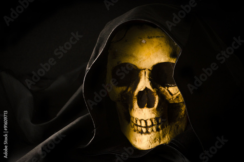 Halloween concept of scary skull head in black hood
