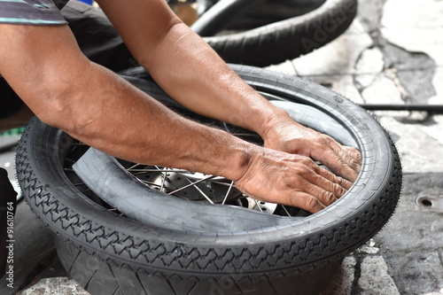 Motorcycle mechanic changing a wheel.