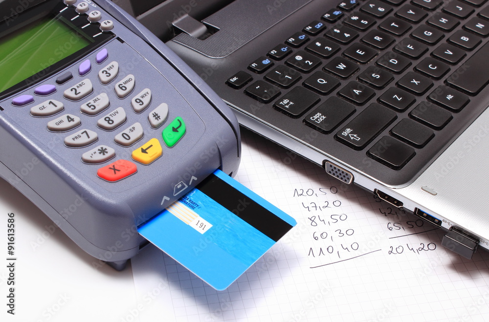 Payment terminal with credit card, laptop and financial calculations Payment terminal with credit card, laptop and financial calculations