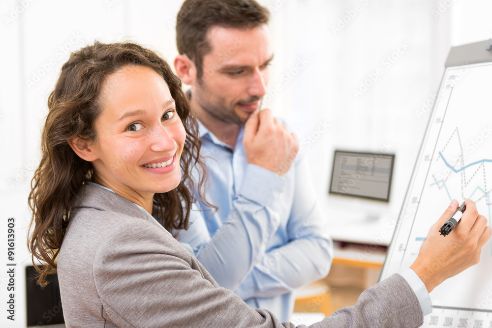 Obraz premium Business man and woman, analysing stats on a paperboard