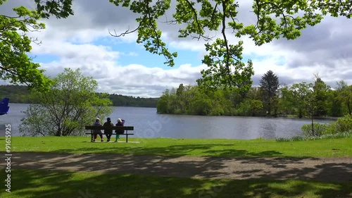 People sit on a bench enjoying the scenery at Loch Lomand Scotland. photo