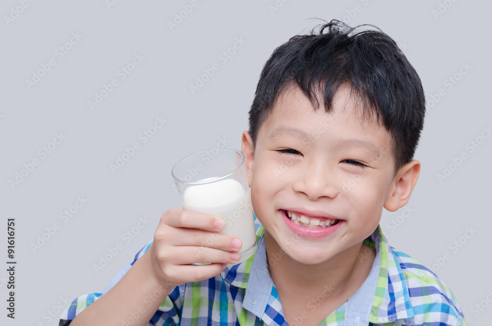 Asian boy smiles and holding a glass of milk Asian boy smiles and holding a glass of milk