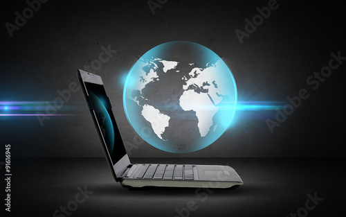open laptop computer with globe projection