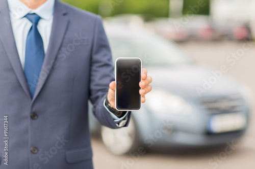 close up of business man with smartphone and car